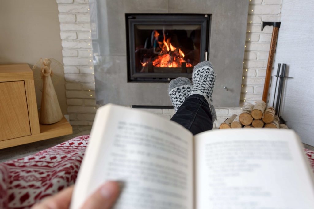 Reading a book by a fire